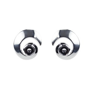 May include: A pair of silver earrings with a spiral design and a small black stone in the center.