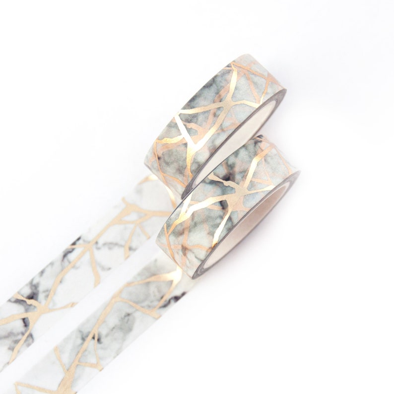 K&ouml;nnte beinhalten: Zwei Rollen Washi-Tape mit Marmor- und Golddesign. Das Band ist wei&szlig; mit einem grauen Marmormuster und goldenen Linien.