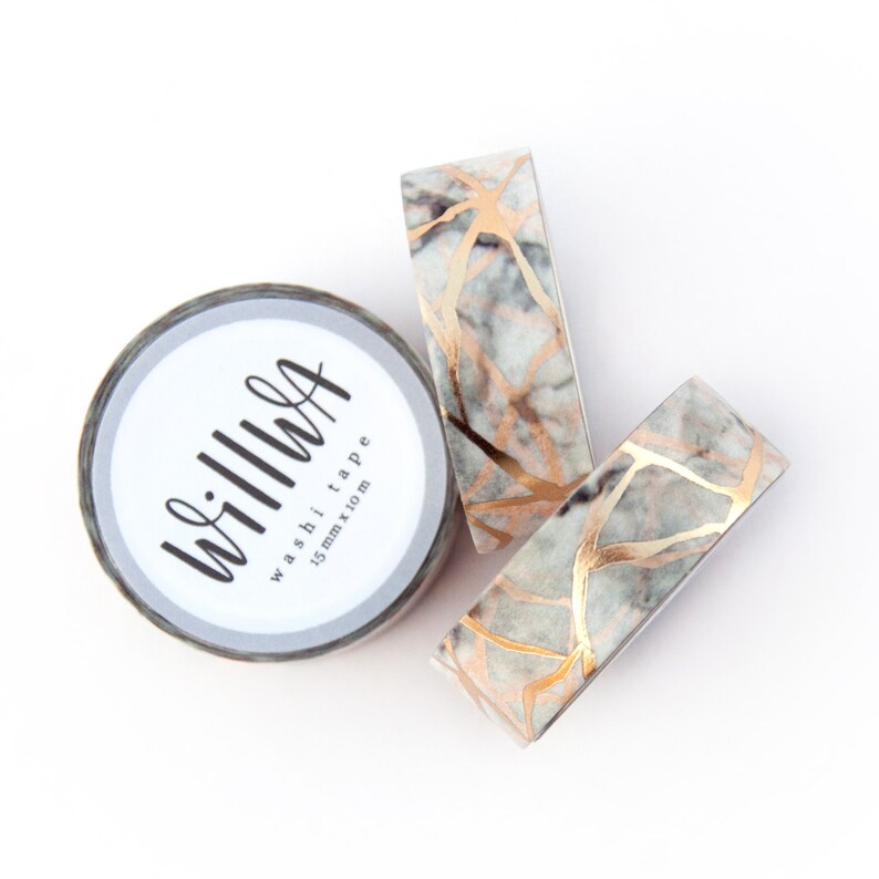 K&ouml;nnte beinhalten: Drei Rollen Washi-Tape mit Marmor- und Goldfoliendesign. Das Band ist 15 mm breit und mit "Washi Tape 15 mm x 10 m" und "willwa" beschriftet.