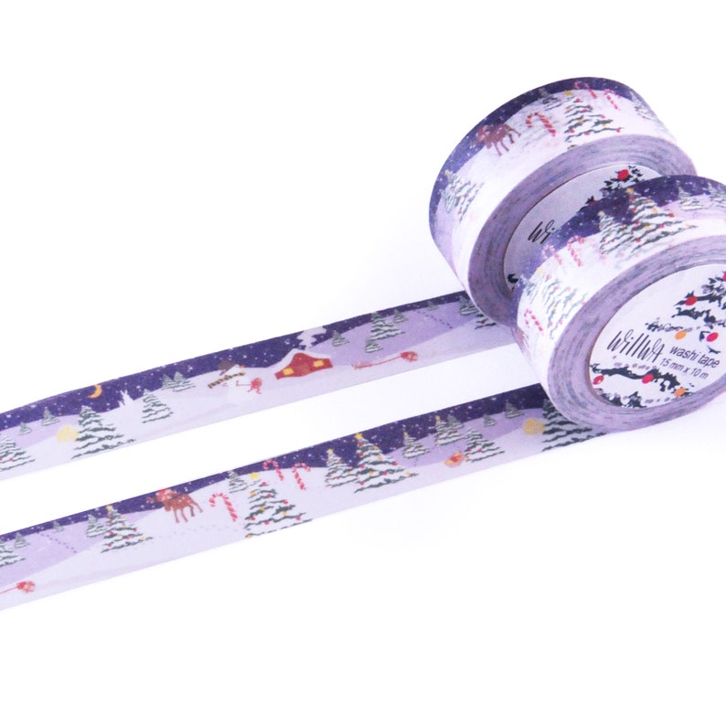 May include: Purple washi tape with a winter scene featuring snow-covered trees, a house, and a reindeer. The tape is 15 mm wide and 10 m long.