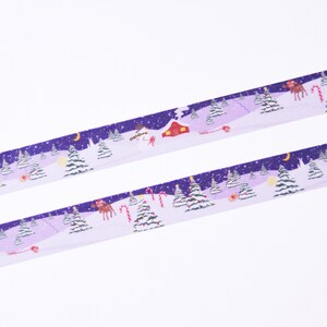 May include: Purple and white washi tape with a winter scene featuring snow-covered trees, a red cabin, a reindeer, and candy canes. The tape has a glittery finish.