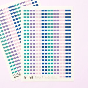 May include: Two sheets of washi tape with a repeating pattern of small squares in shades of blue, green, purple, and pink. The text "Stripe 1 - washi strips" is printed on the bottom of the sheet.