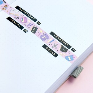 May include: A pink and purple washi tape with a pattern of stars, scissors, pencils, and other stationery items. The tape is labeled "SUNDAY 30", "WEDNESDAY 26", "THURSDAY 27", and "GOALS".