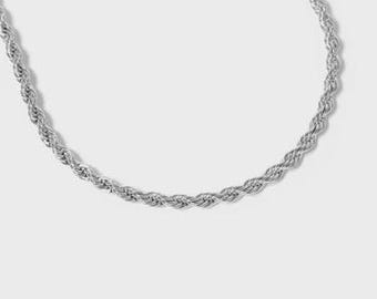 May include: A silver-colored rope chain necklace. The chain is made of tightly twisted links, creating a textured, rope-like appearance. The necklace is displayed against a plain white background, highlighting its metallic sheen and design.