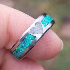 May include: A silver ring with a heart-shaped inlay and a band of green opal.