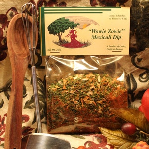 May include: A clear plastic bag filled with a mix of dried herbs, spices, and vegetables. The bag is labeled "Wowie Zowie" Mexicali Dip, Net Wt. 2 oz., Yield: 6 Batches (1 Batch = 1 Cup), A Product of Cooks, Crafts & Rumors.