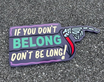 May include: Purple and white sign with a skeleton hand pointing to the right. The sign reads "If you don't belong, don't be long!"