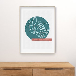 May include: Framed art print with the quote "He must increase, but I must decrease" in white script. The text is set against a teal circle, with a red banner at the bottom. The print is in a gold frame.