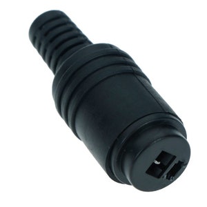 May include: Black plastic connector with two prongs. The connector has a ribbed design and is used for connecting electronic devices.