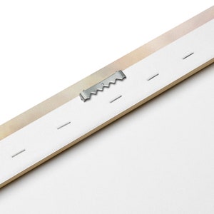 May include: Close-up of the back of a canvas print, showing a metal hanging hook and small nails securing the canvas to the wooden frame.