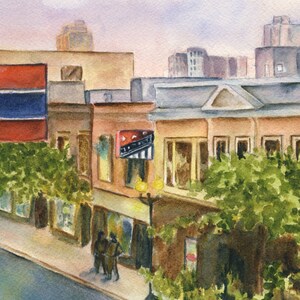 May include: A watercolor painting of a city street scene with buildings, trees, and people. The buildings are painted in shades of brown, yellow, and red. The trees are green and the people are wearing dark clothing. There is a sign on one of the buildings that says "The Roxy".