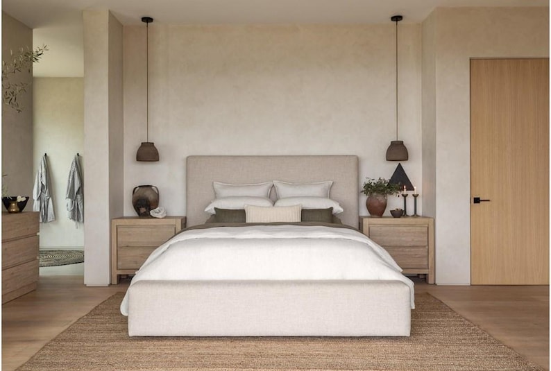 K&ouml;nnte beinhalten: Ein Schlafzimmer in neutralen T&ouml;nen mit Bett, Nachttischen und Teppich. Das Bett hat ein beiges Kopfteil und wei&szlig;e Bettw&auml;sche. Zwei Nachttische aus Holz flankieren das Bett, jeder mit einer Lampe und dekorativen Gegenst&auml;nden. Ein gewebter Teppich bedeckt den Boden.