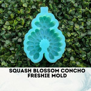 May include: A turquoise blue silicone mold shaped like a squash blossom. The mold is designed to create a concho freshie, a type of decorative charm.
