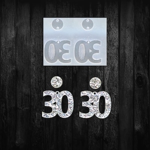 May include: A clear silicone mold with the number "30" and two pairs of silver glitter "30" earrings. The earrings have a round top with a hole for hanging. The background is a dark wood grain.