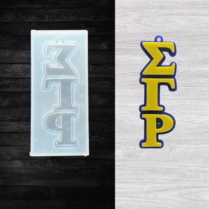 May include: A clear silicone mold and a finished charm. The mold is rectangular with the Greek letters ΣΓΡ in a vertical arrangement. The finished charm is yellow with blue trim, also featuring the Greek letters ΣΓΡ.