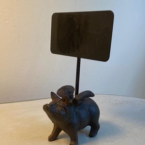 Gietijzeren vliegend varken met bord