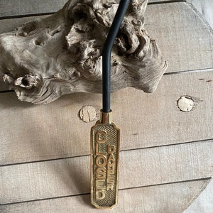 以下が含まれることがあります： 黒い金属製の暖炉のダンパーフック。真鍮製のハンドルには、「CLOSED DAMPER」という文字が浮き彫りにされています。