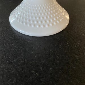 May include: White milk glass pedestal with a textured, dotted base.