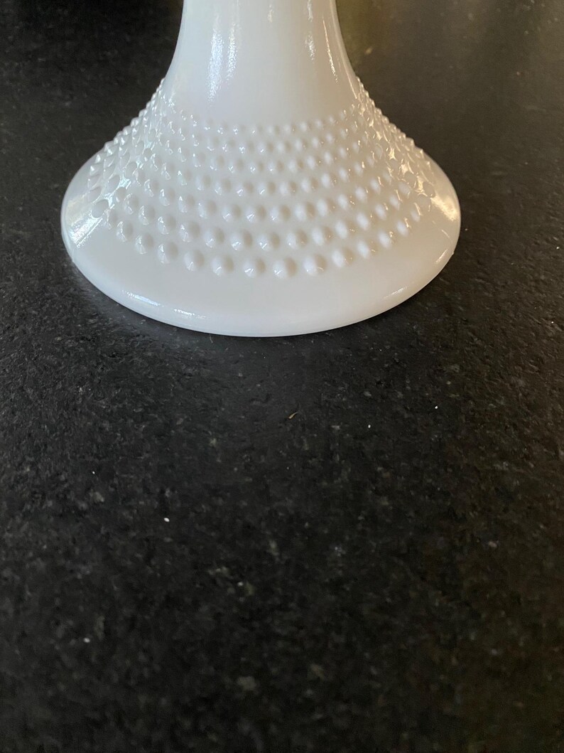 May include: White milk glass pedestal with a textured, dotted base.