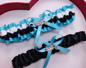 May include: Two blue and black garters with a silver motorcycle charm. The garters are made of satin ribbon and have a white stripe.