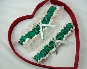 May include: Two white and green garters with silver heart charms in a red heart-shaped box.