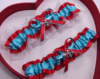 May include: Two blue and red garters with white lace and silver arrow charms.