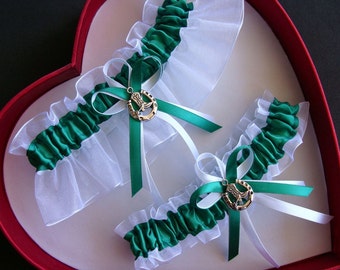 May include: Two white and green bridal garters with a silver horseshoe charm. The charms feature a boot design.