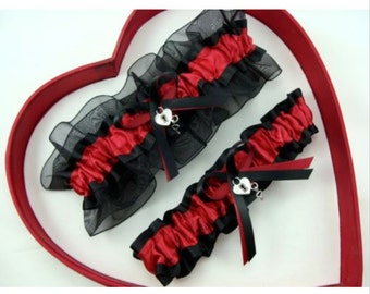 May include: Two red and black garters with a heart-shaped charm. The garters are made of satin and lace.