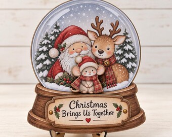May include: A decorative snow globe ornament featuring a printed illustration of Santa Claus, a reindeer, and a mouse wearing a scarf. The base is wood-toned with a plaque that reads "Christmas Brings Us Together" and includes holly and a red heart.