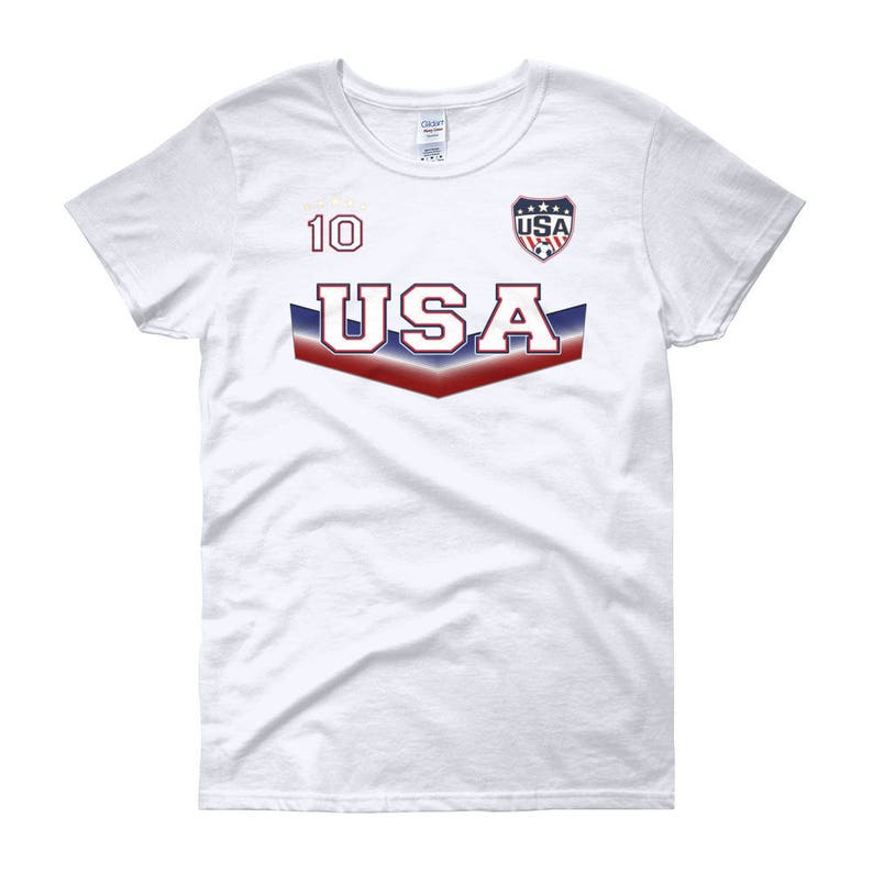 May include: White women's t-shirt with a red, white, and blue USA graphic and the number 10 on the front.