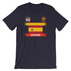 May include: Navy blue t-shirt featuring the Spanish flag design. The shirt includes the number 10, a crest, and the word "Espa&ntilde;a" in white. The design incorporates the colors red, yellow, and white.
