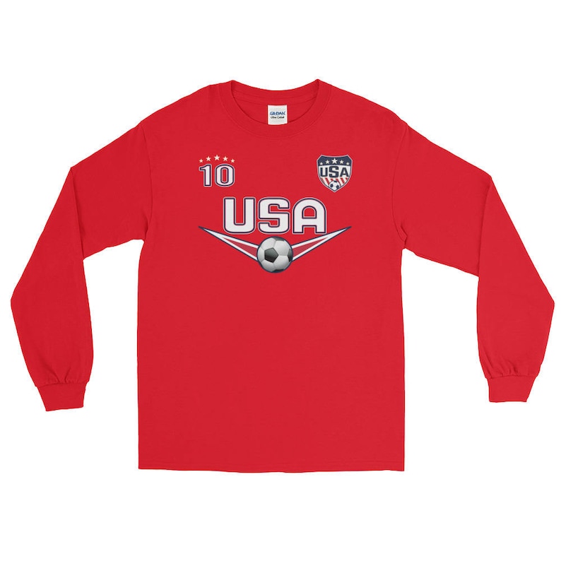 May include: Red long-sleeve shirt with a white and blue USA soccer jersey design. The shirt has a white soccer ball graphic and the number 10 on the front.