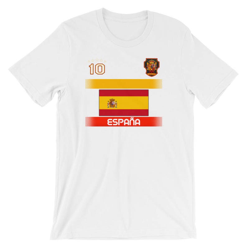 May include: White t-shirt featuring the Spanish flag design. The shirt has a gold and red horizontal stripe design, the word "ESPA&Ntilde;A" in red, and the number "10" in gold.