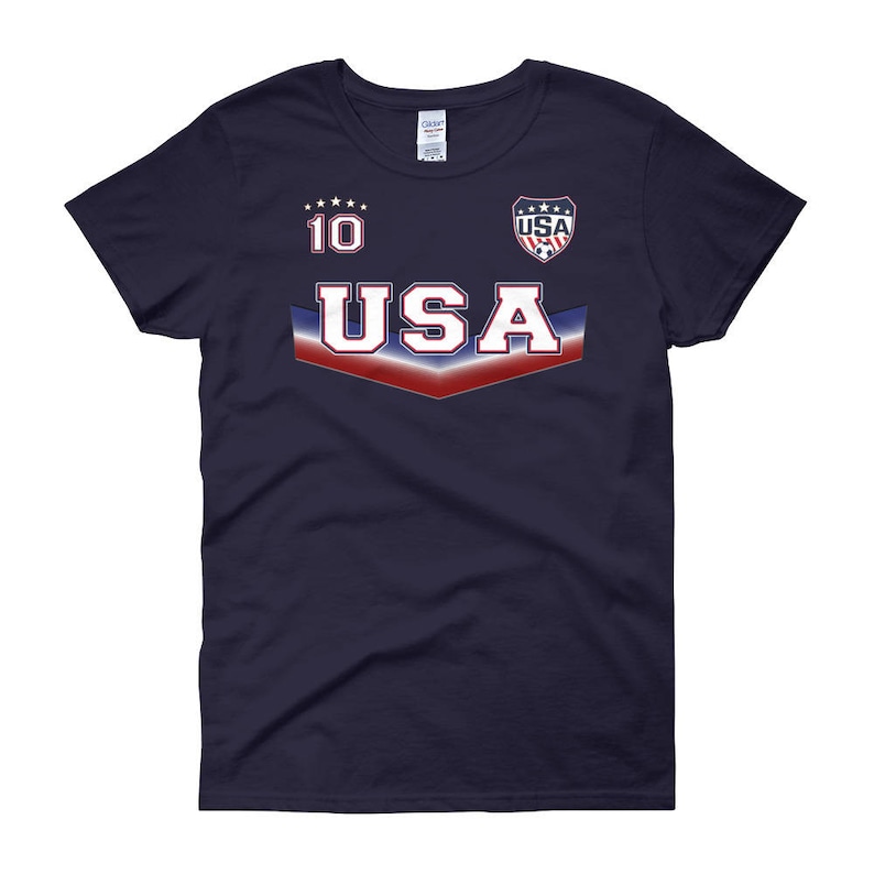 May include: A navy blue women's t-shirt with a white, red, and blue USA graphic. The graphic includes the number 10 and a soccer ball.