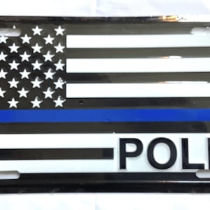 May include: Black and white American flag with a blue stripe across the bottom and the word "POLICE" in white letters.