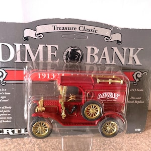 May include: A red 1913 Agway Dime Bank die-cast metal replica toy truck. The truck has a white "Agway" logo on the side and is 1/43 scale.