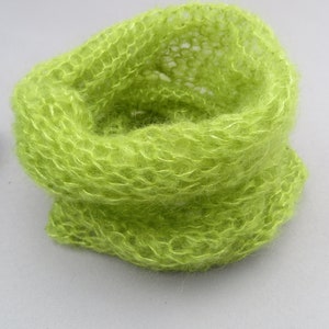 May include: A lime green knitted cowl made from a soft, fuzzy yarn.