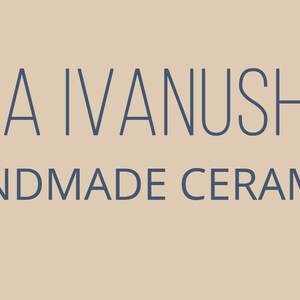 May include: The image displays the text "OLENA IVANUSHKINA HANDMADE CERAMICS" in a dark blue font. The text is centered on a light tan background. The words are in a sans-serif font.