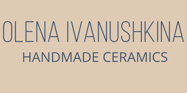 May include: The image displays the text "OLENA IVANUSHKINA HANDMADE CERAMICS" in a dark blue font. The text is centered on a light tan background. The words are in a sans-serif font.