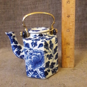 Miniature Chinese porcelain teapot of hexagonal section, with a cast brass handle.