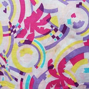 May include: A pink, yellow, blue, and purple fabric with a geometric pattern of circles and palm trees.