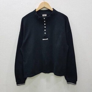 Puede incluir: Camiseta negra de manga larga con cuello alto y cierre de botones. La camisa tiene ribetes blancos en los puños y el cuello.