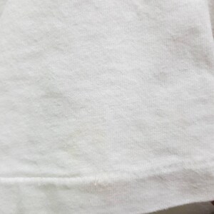 Puede incluir: Primer plano de una camiseta de algod&oacute;n blanco lisa. La tela tiene una textura suave y un aspecto ligeramente acanalado.