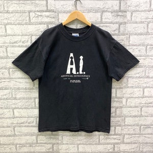 May include: Black t-shirt with a white graphic of the movie title "A.I. Artificial Intelligence" with the release date "June 29, 2001" and the text "At the Theaters".