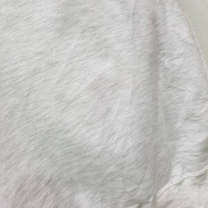 May include: A white sweatshirt with a soft, textured fabric. The sweatshirt has a ribbed hem and cuffs.