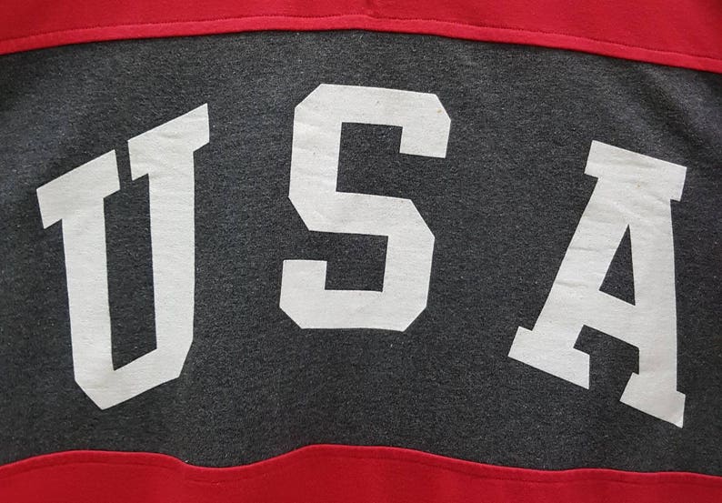 May include: A gray and red shirt with the word "USA" printed in white on the gray section.