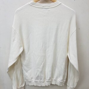 May include: A white long-sleeved sweatshirt with a crew neck.