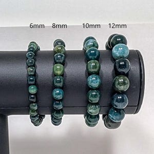 May include: Four green agate bead bracelets displayed on a black stand. The bracelets are 6mm, 8mm, 10mm, and 12mm in diameter.