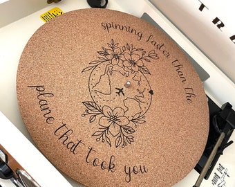 May include: A cork record player slipmat with a black and white illustration of a globe with flowers and an airplane. The text "spinning faster than the plane that took you" is printed on the slipmat.