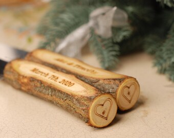May include: A pair of wooden cake cutting knives with a heart design and the date "March 7th, 2020" engraved on the handles.